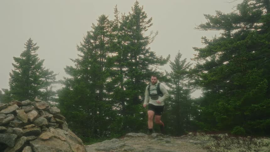 Man running on a trail in the mountains