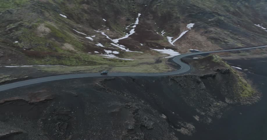 An aerial view of a car traveling on the coastal line
