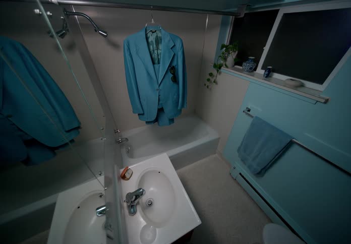 View of a blue suit hanging over a bathtub