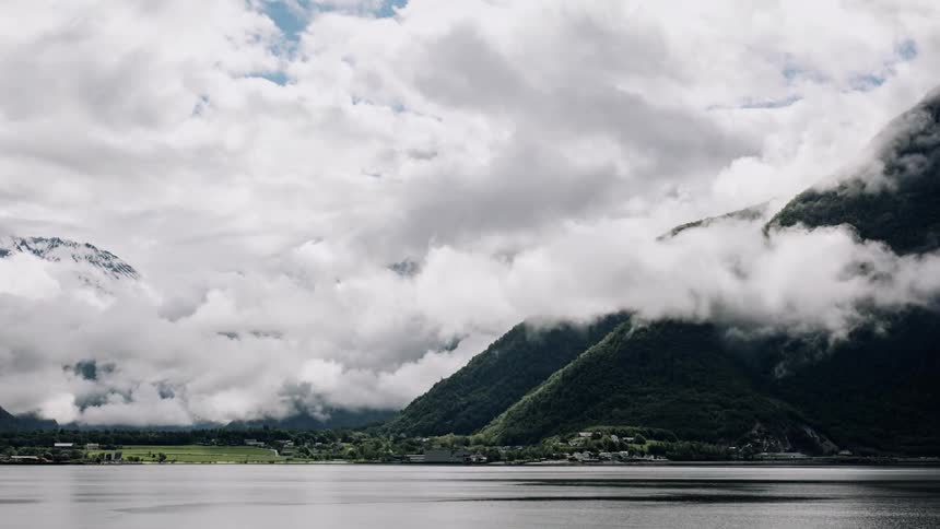 Timelapse of clouds passing through the mountains with a central sea