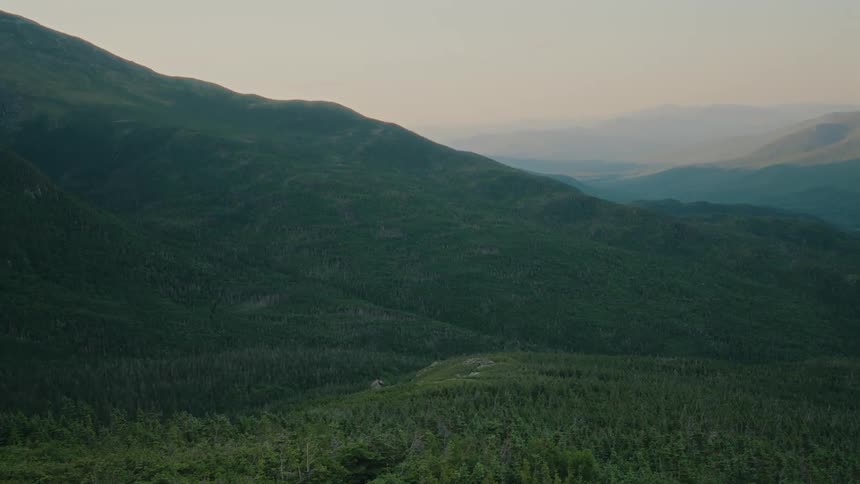 Panorama of mountains covered in forests with a morning sky