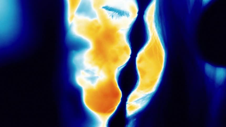 A woman breaths deeply while a thermal image of her face is captured