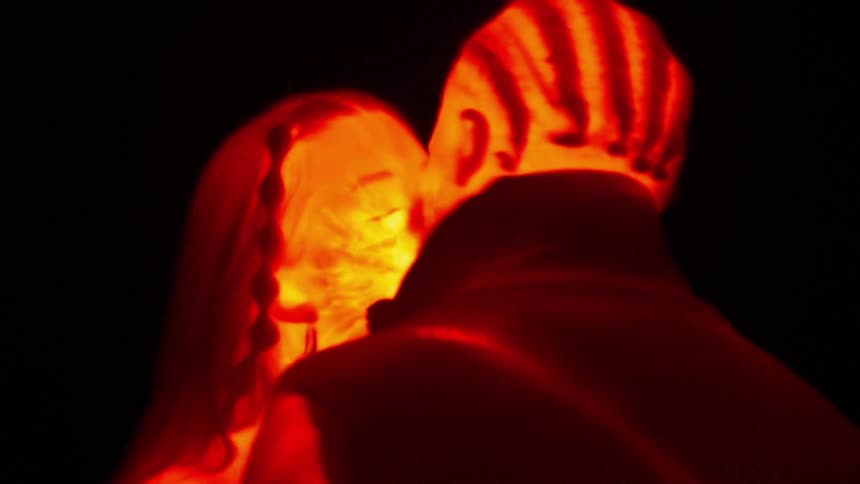 Man and woman in an animation of a heat map kissing on a black background