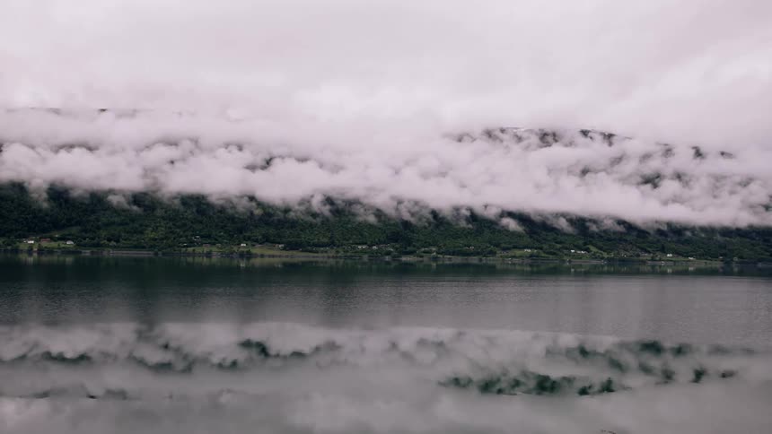 Sea coast with mountains covered by clouds