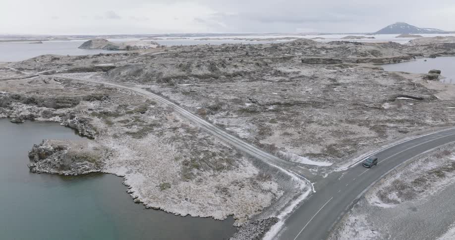 Highway with a vehicle turning on the road in a natural area with the sea beside it