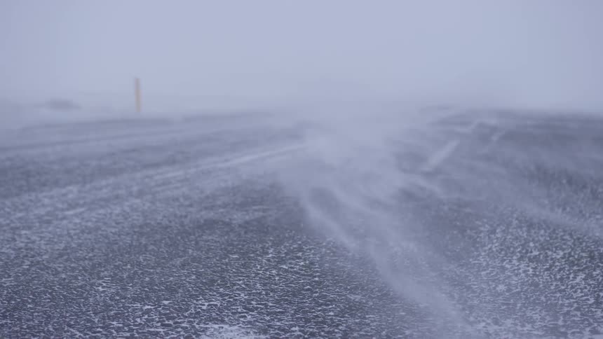 Wind blows down the road in whiteout conditions