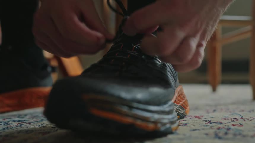 A person tying his tennis shoelaces