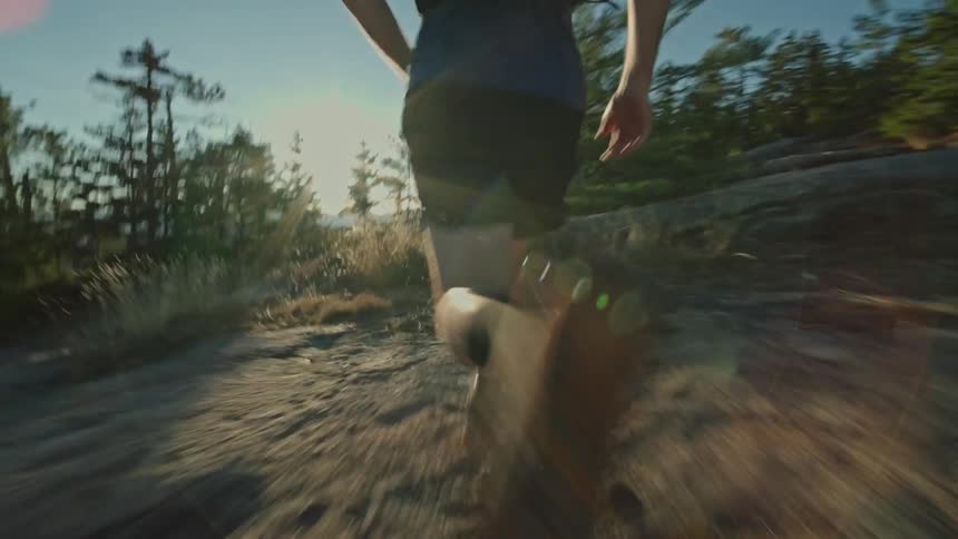 Man running on a rock on a trail in nature during a sunny day