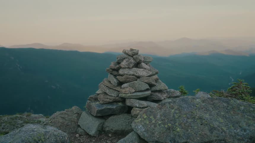 A group of rocks are stacked like a triangle in a remote mountainous area