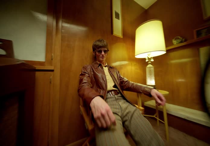 Portrait of a person sitting in a chair in a room