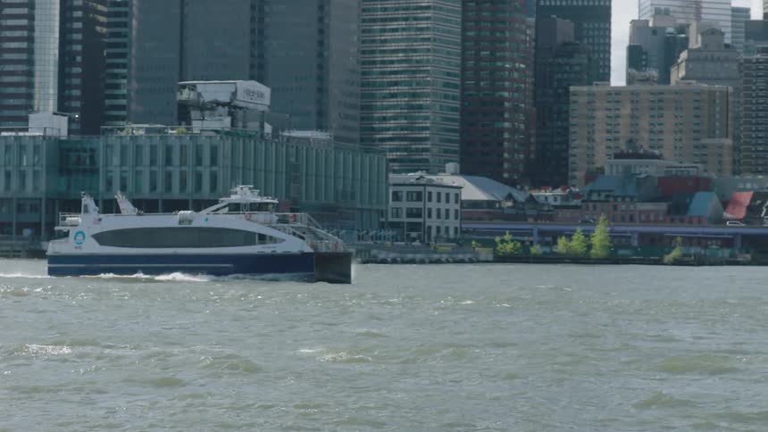 Ferry boat cruises by waterfront buildings during the day