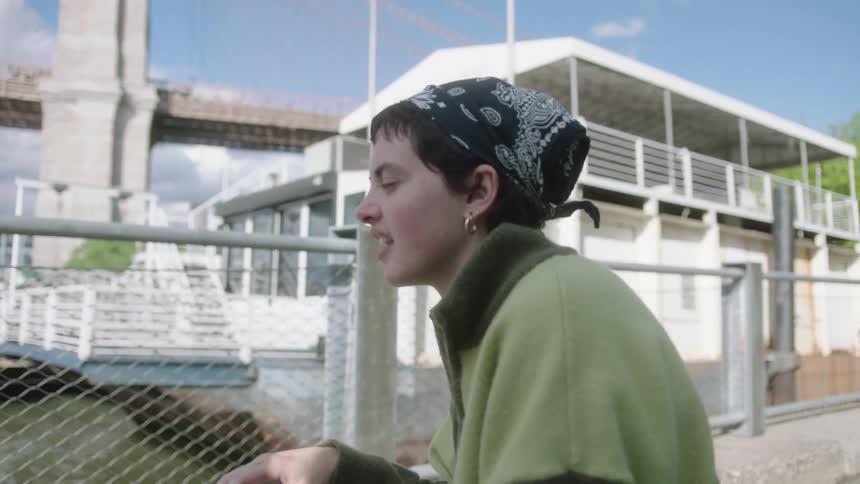 Woman sits on bench on the waterfront and talks with a friend