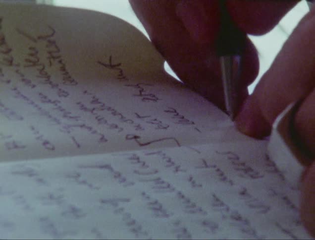 A person is writing in a notebook