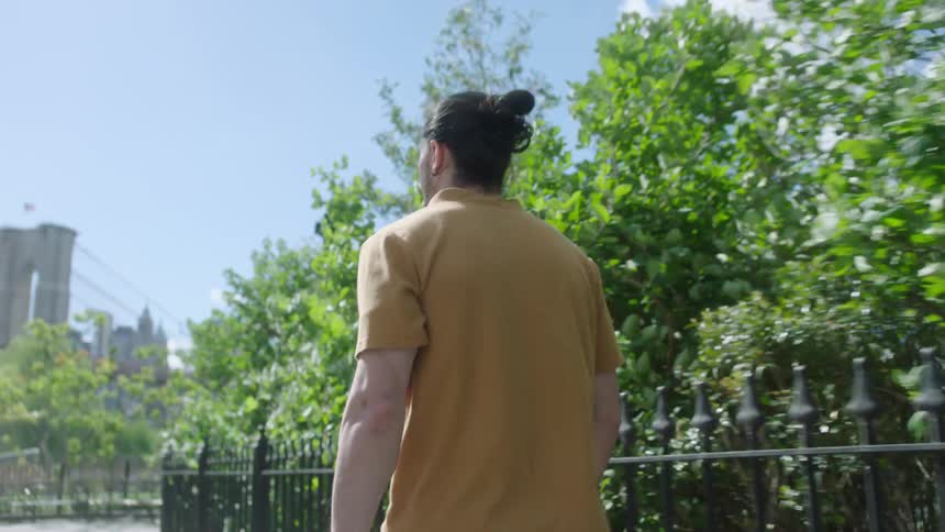 Man walking through the city with his back turned during the day
