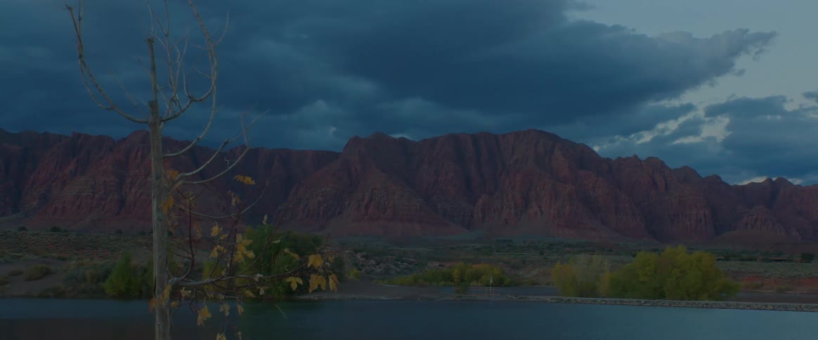 Landscape of a lake with mountains in the background under a cloudy sky