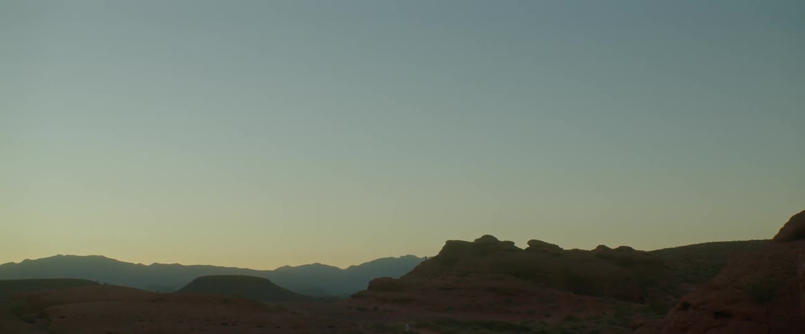 Under a completely cloudless sky is a rocky mountain range
