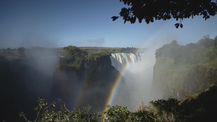 A rainbow in the forest waterfall during summer