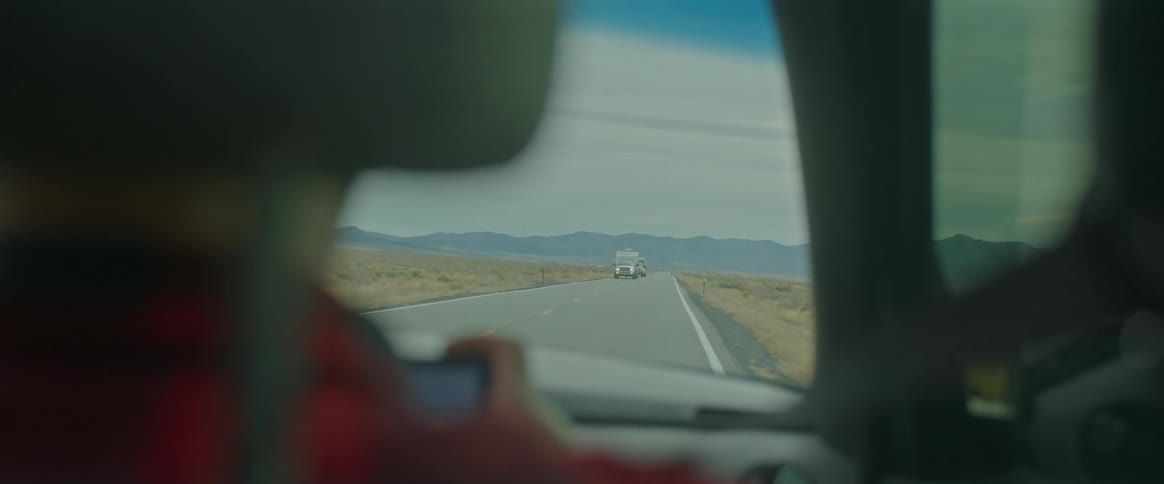 Driving on a twolane highway in the wide open countryside at the base of the mountains
