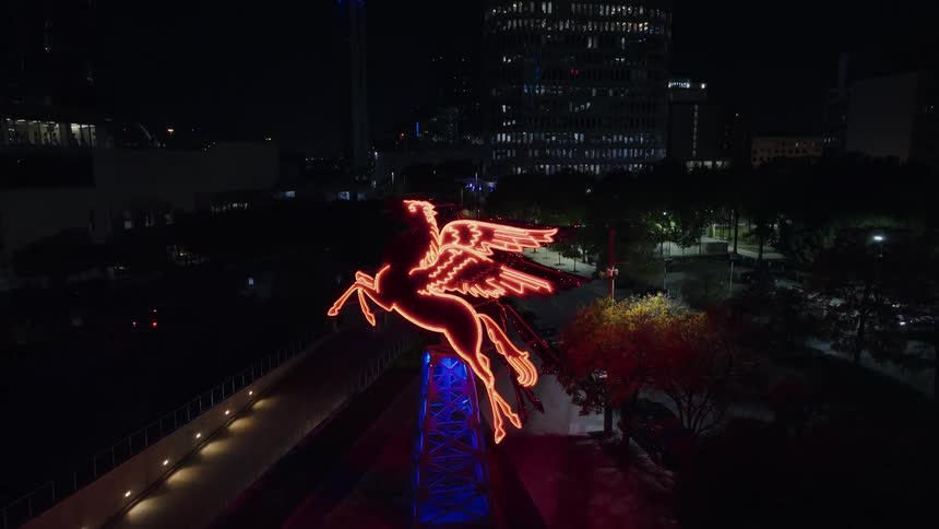 A statue of a horse with neon lights in a city