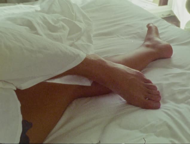 Legs intertwined on the bedroom bed