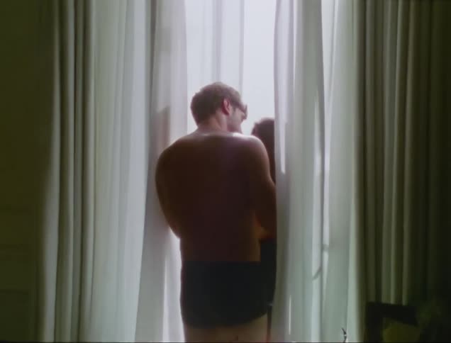 Young couple kiss while looking out of the balcony