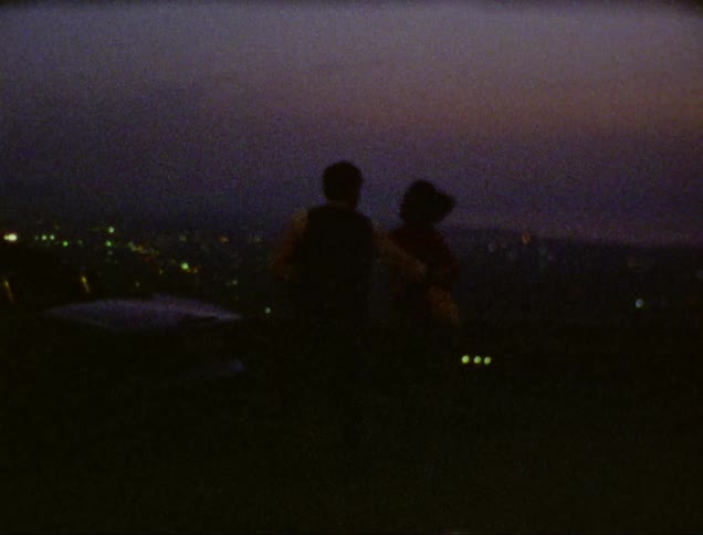 A man and a woman dancing outdoors at dusk