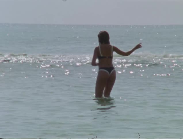 A woman entering the sea during a hot summer day