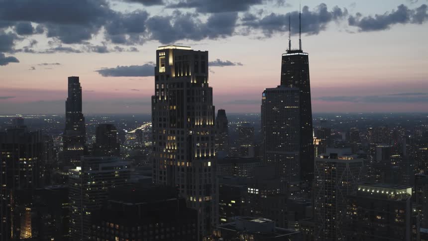 Skyline of a city with towers and skyscrapers illuminated during sunset