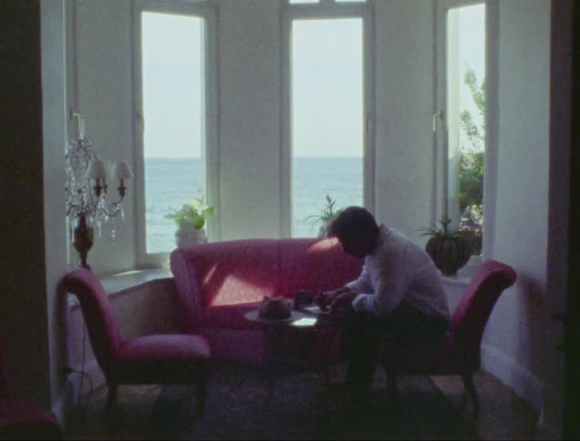 A man is writing in an ocean front room
