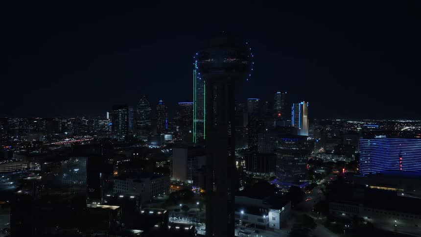 A tower with a ball full of lights in a city at night