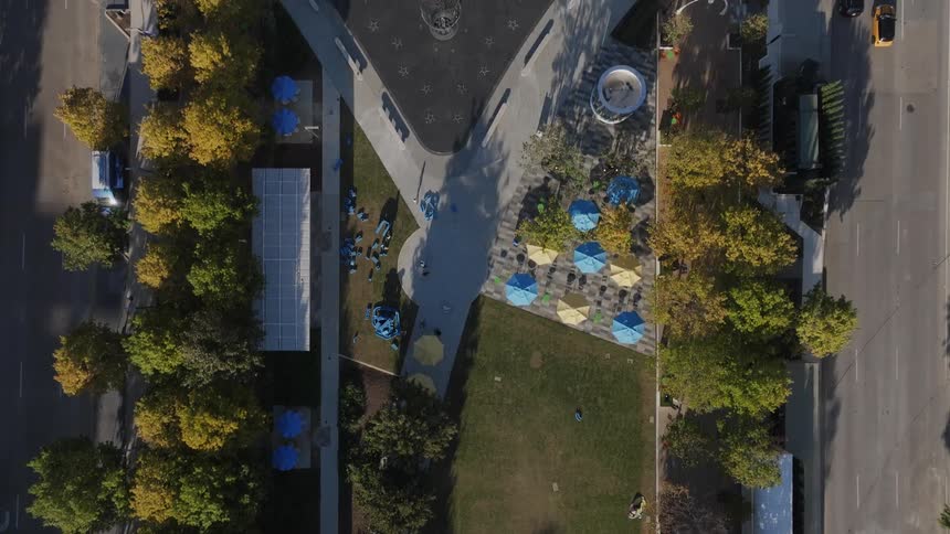 An aerial view of a fountain in a park and cars driving on highways