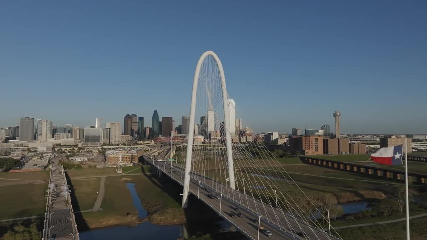 View of a cablestayed bridge and city skyline with the bridges white tower standing out against the backdrop of skyscrapers and other buildings