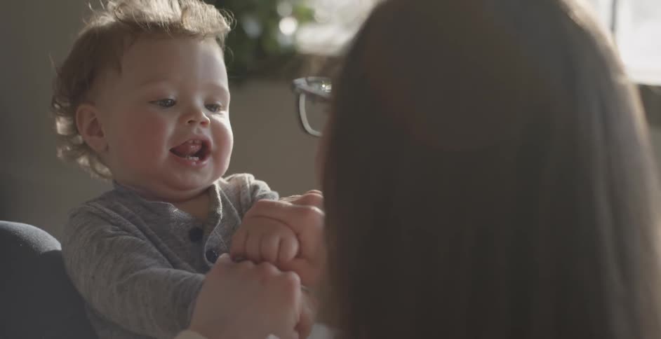 A woman is playing with a baby