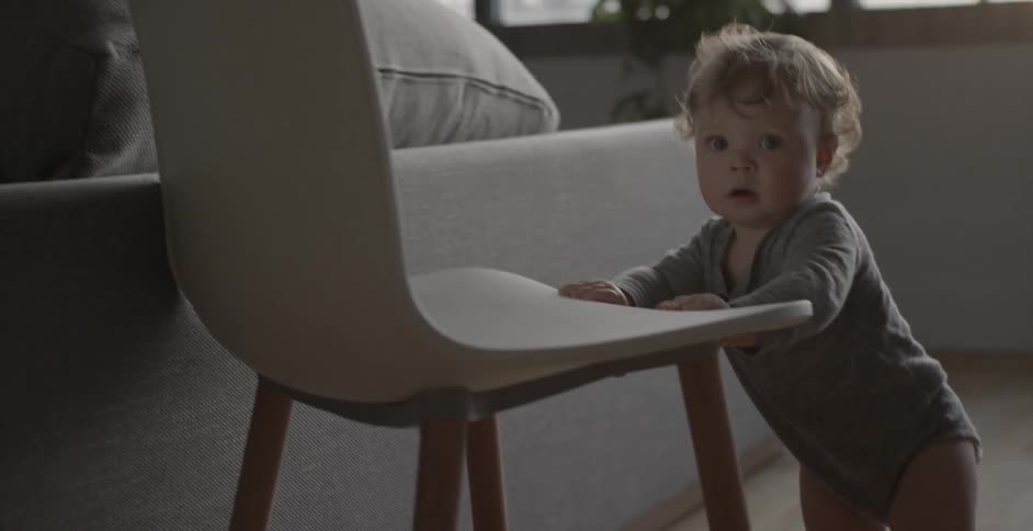 A baby is pushing a chair
