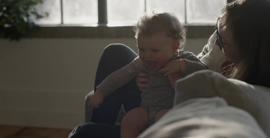 A woman kisses a baby in her lap
