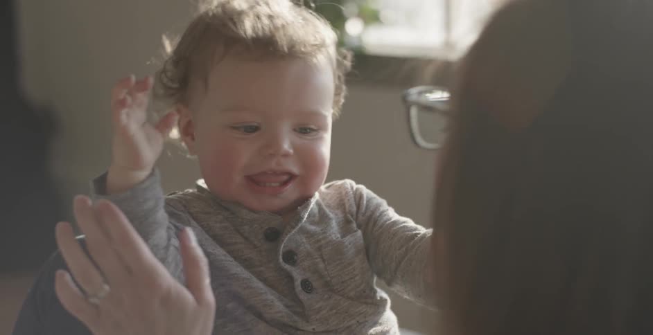 A woman is playing with a baby