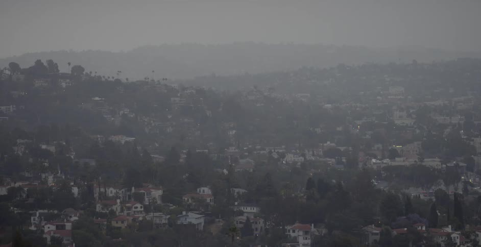 The hillside town is covered with fog below