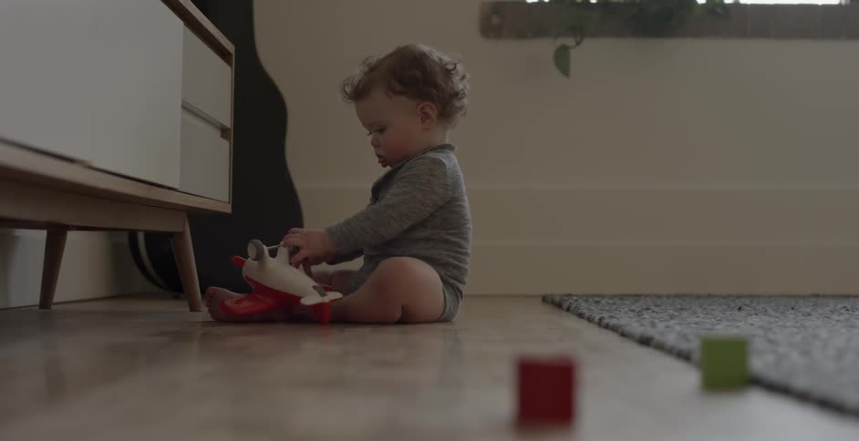 A child playing near a dresser