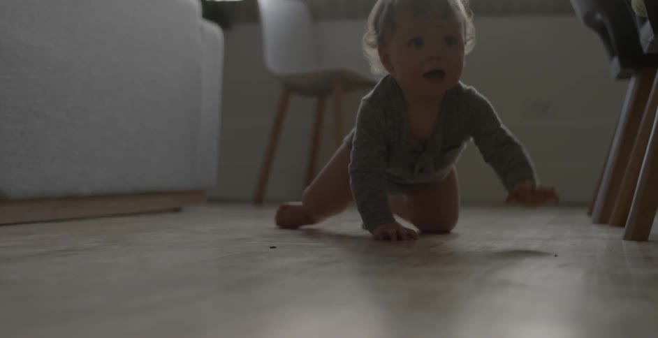 A baby crawls along the floor