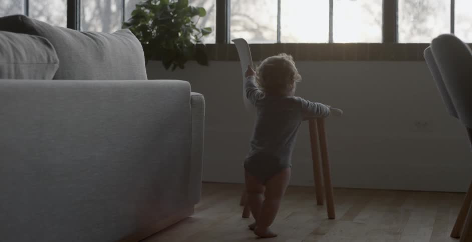 Baby pushes a chair across the floor