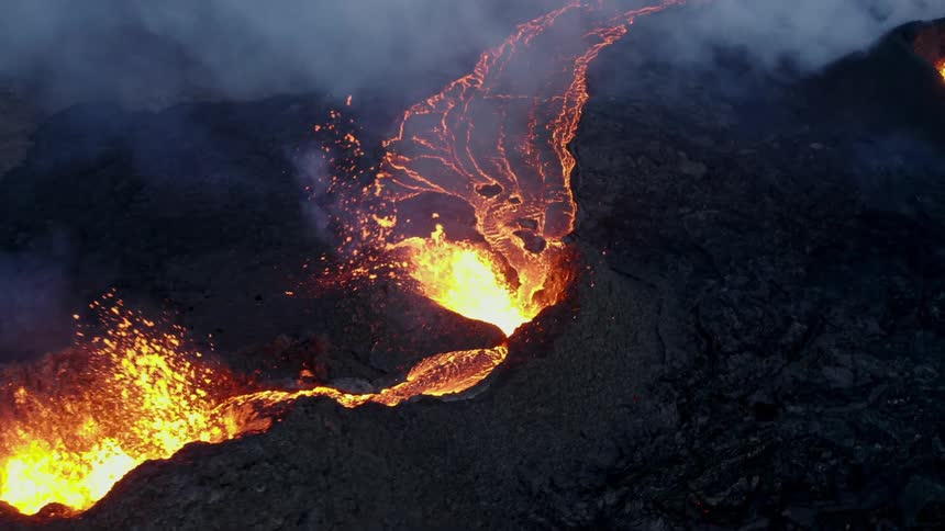 Erupting volcano outdoors with lava flows and smoke