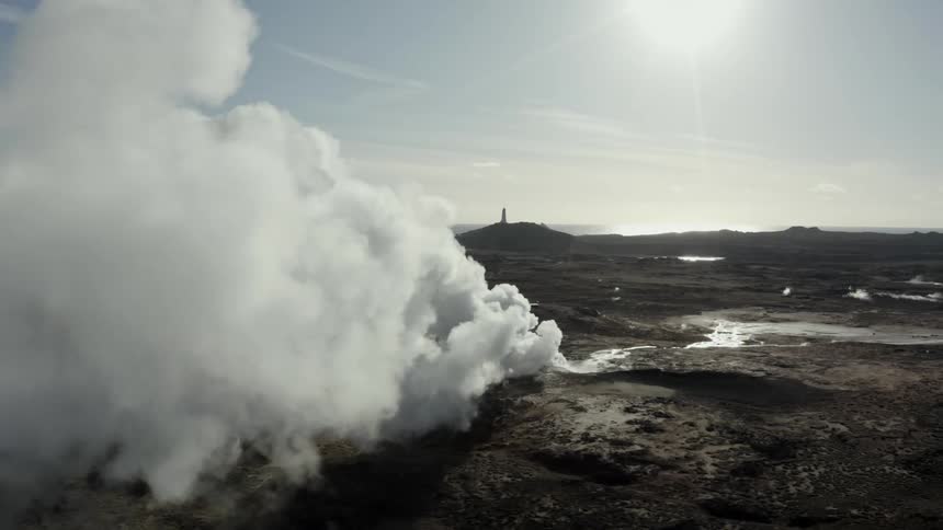 Steam smoke rises from ground outdoors during the day