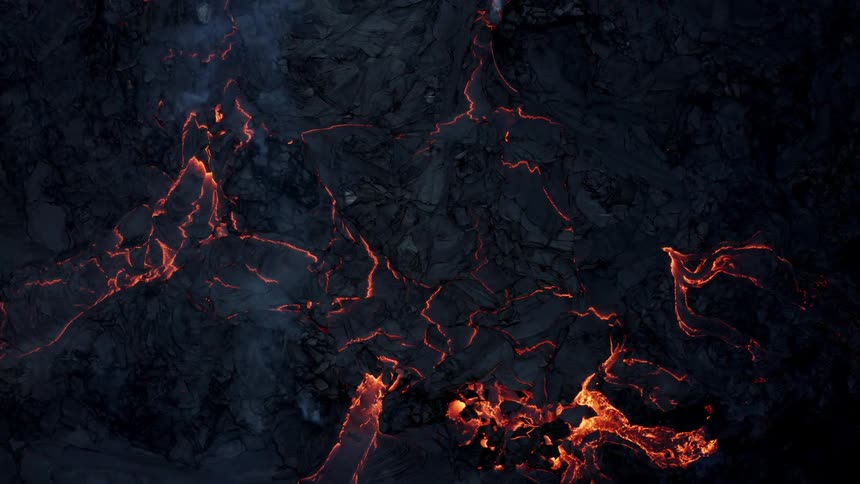 Aerial of smoke rising from ash covered lava