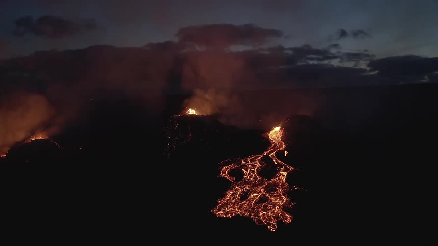 A small volcano that is erupting and spewing magma onto the rocks next to it