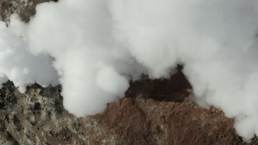 White smoke steam billows from rocks