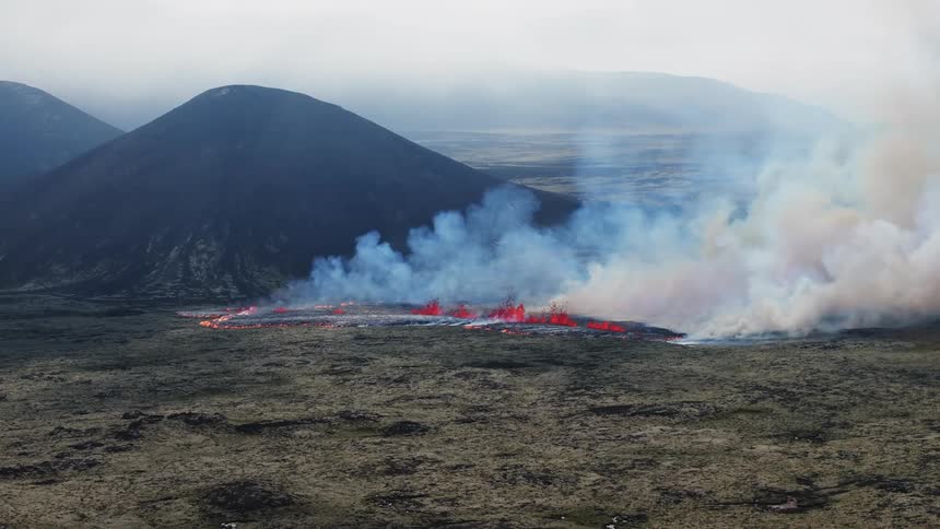 The aftermath of a volcano with smoking piles of lava beside it