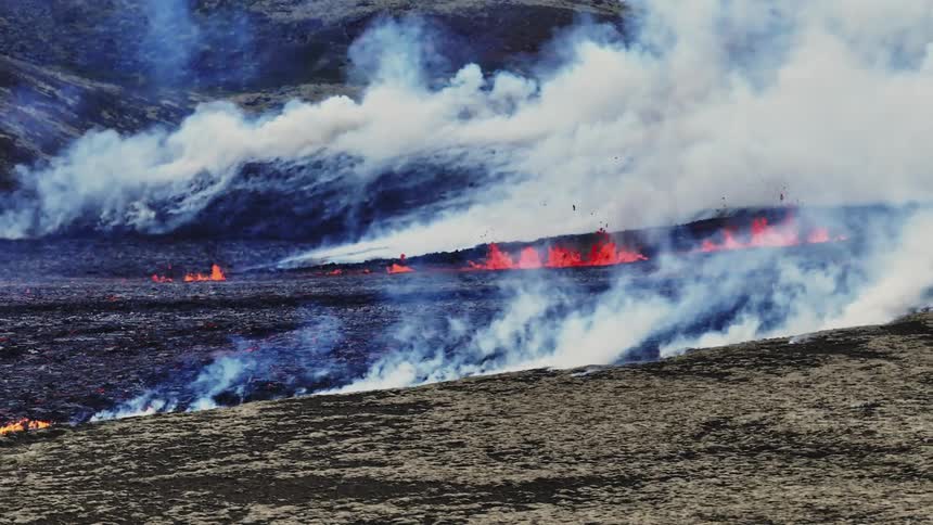 Thick smoke rises from erupting lava and nearby fire