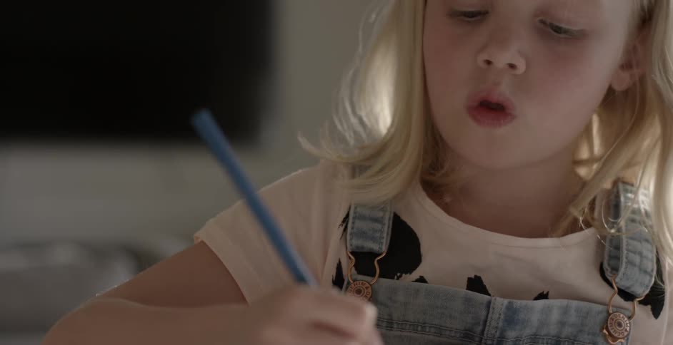 A girl is drawing with a pencil