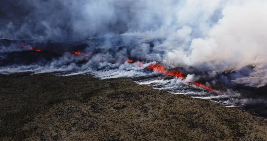 A region with dry grass is burning and making a lot of white smoke