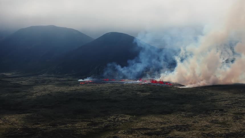 A fire line smolders near the base of a volcano